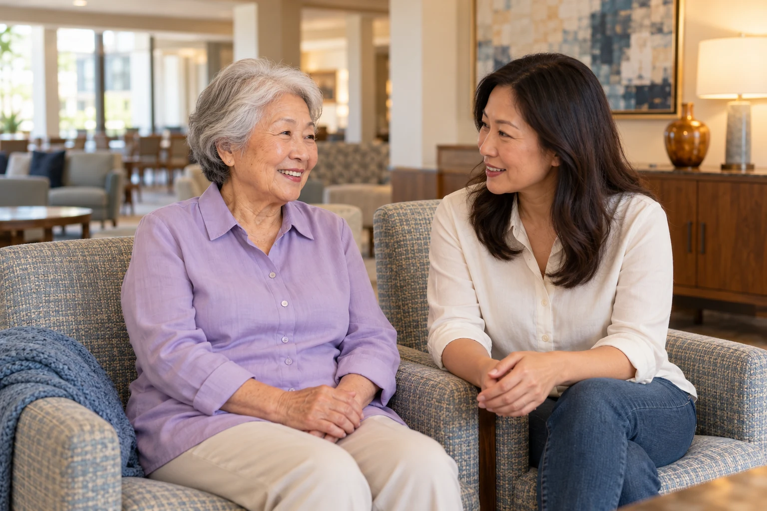 Senior mother and adult daughter having an aging in place conversation on their sofa