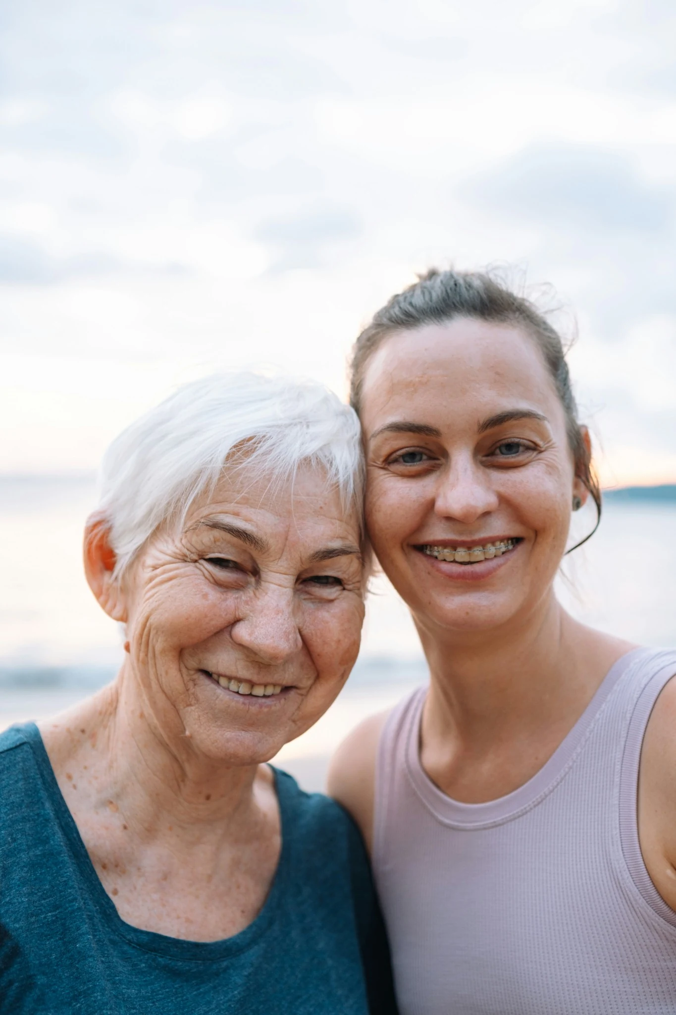 Older woman smiling beside a family member